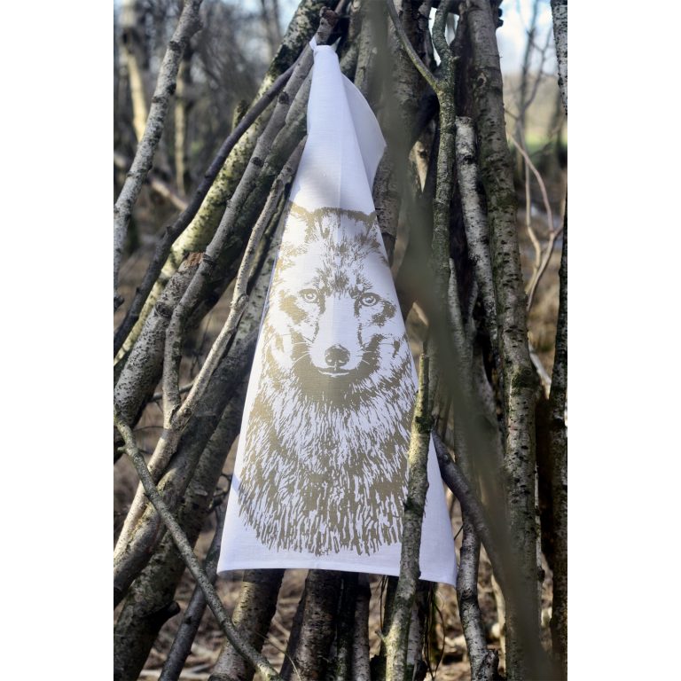 Frohstoff Geschirrtuch mit Fuchs Motiv in Messing zwischen mehrere Äste gehängt in einem Wald