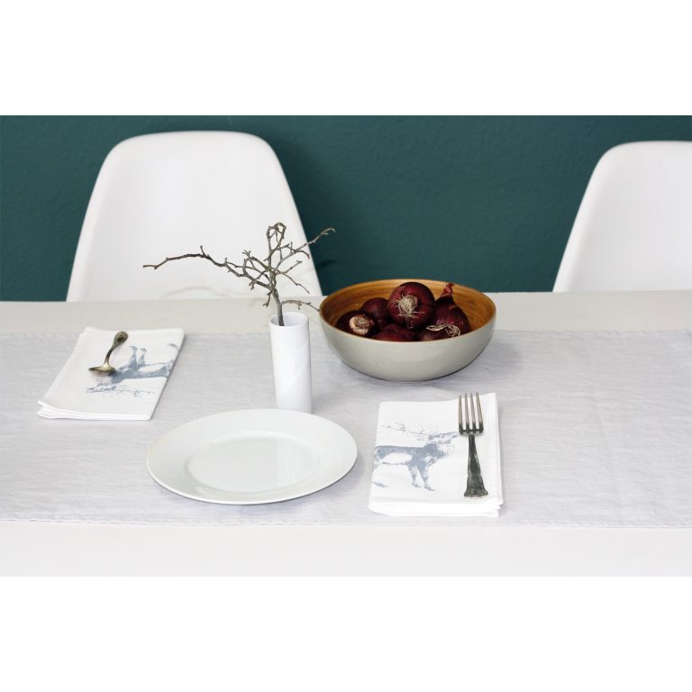 Frohstoff Serviette mit röhrender Hirsch Motiv in graublau auf einem gedeckten Tisch