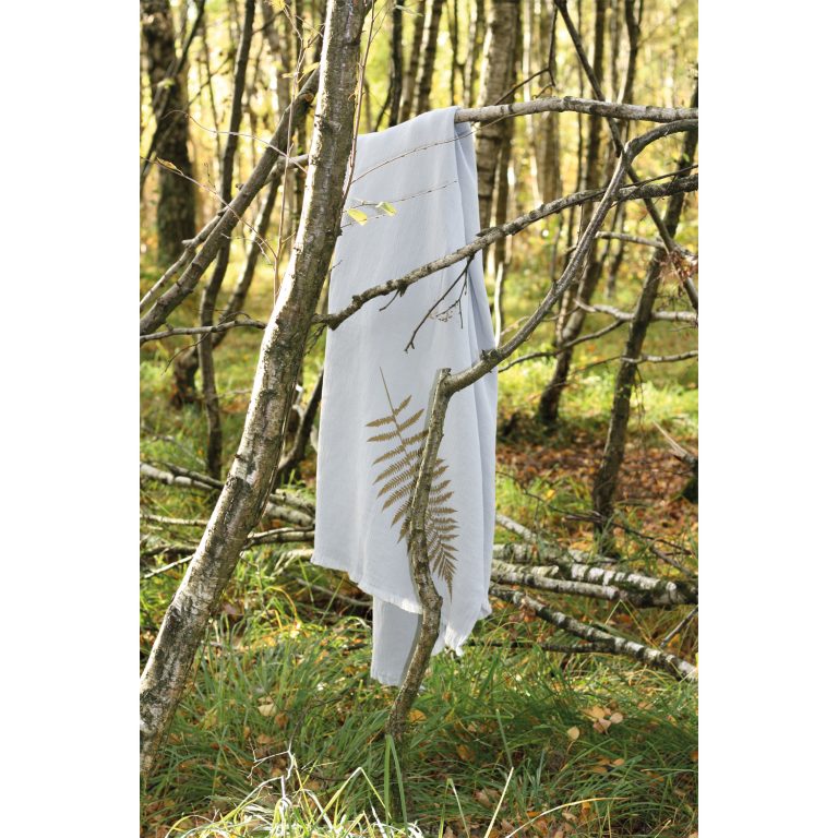 Frohstoff graue Decke mit Farn Motiv in einem Wald über einen querstehenden Ast gelegt