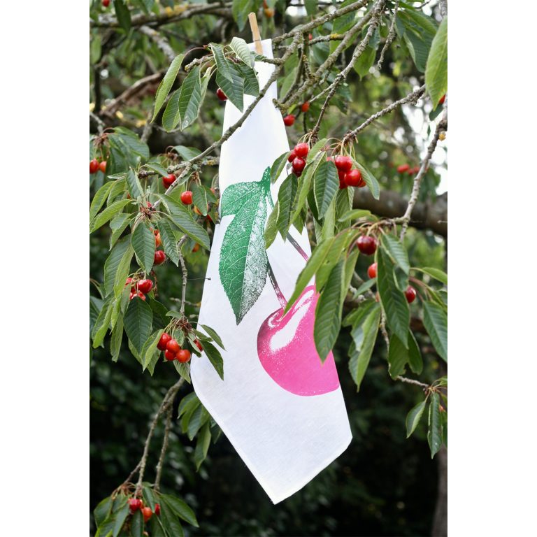 Frohstoff Geschirrtuch mit Kirschen Motiv in pink in einen Kirschenbaum gehängt