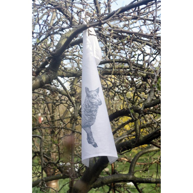Frohstoff Geschirrtuch mit dem Lamm Motiv in einem Baum aufgehängt, der keine Blätter mehr trägt