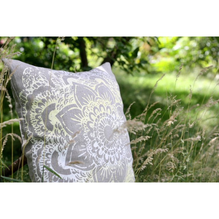 Frohstoff Kissen aus Leinen mit Ornament Motiv in Pastellgelb in hohen Gras mit Natur im Hintergrund