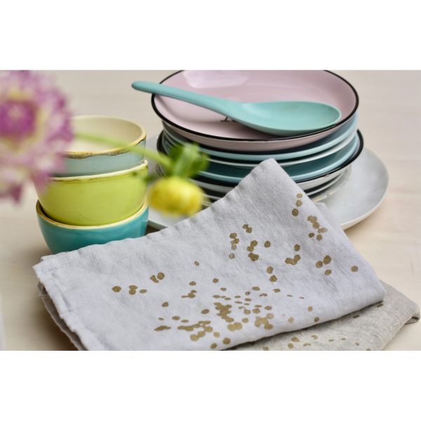Frohstoff Serviette aus Leinen in Grau mit Blüten Motiv zusammengelegt angerichtet neben pastellfarbenen Tellern und Schüsseln