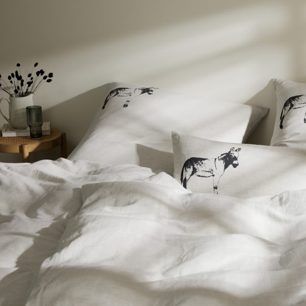Frohstoff verschiedene Kissen mit Esel-Motiv im Farbton Anthrazit in einem Bett dekoriert
