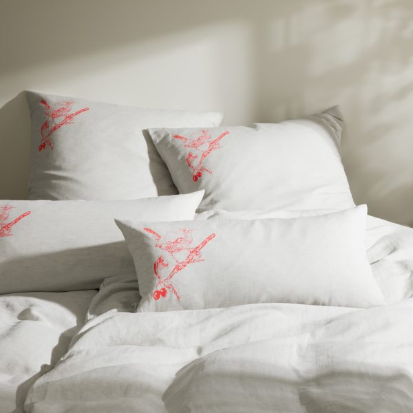 Frohstoff mehrere Kissen in verschiedenen Größen mit Rotkelchen-Motiv im Farbton Koralle in einem Bett liegend