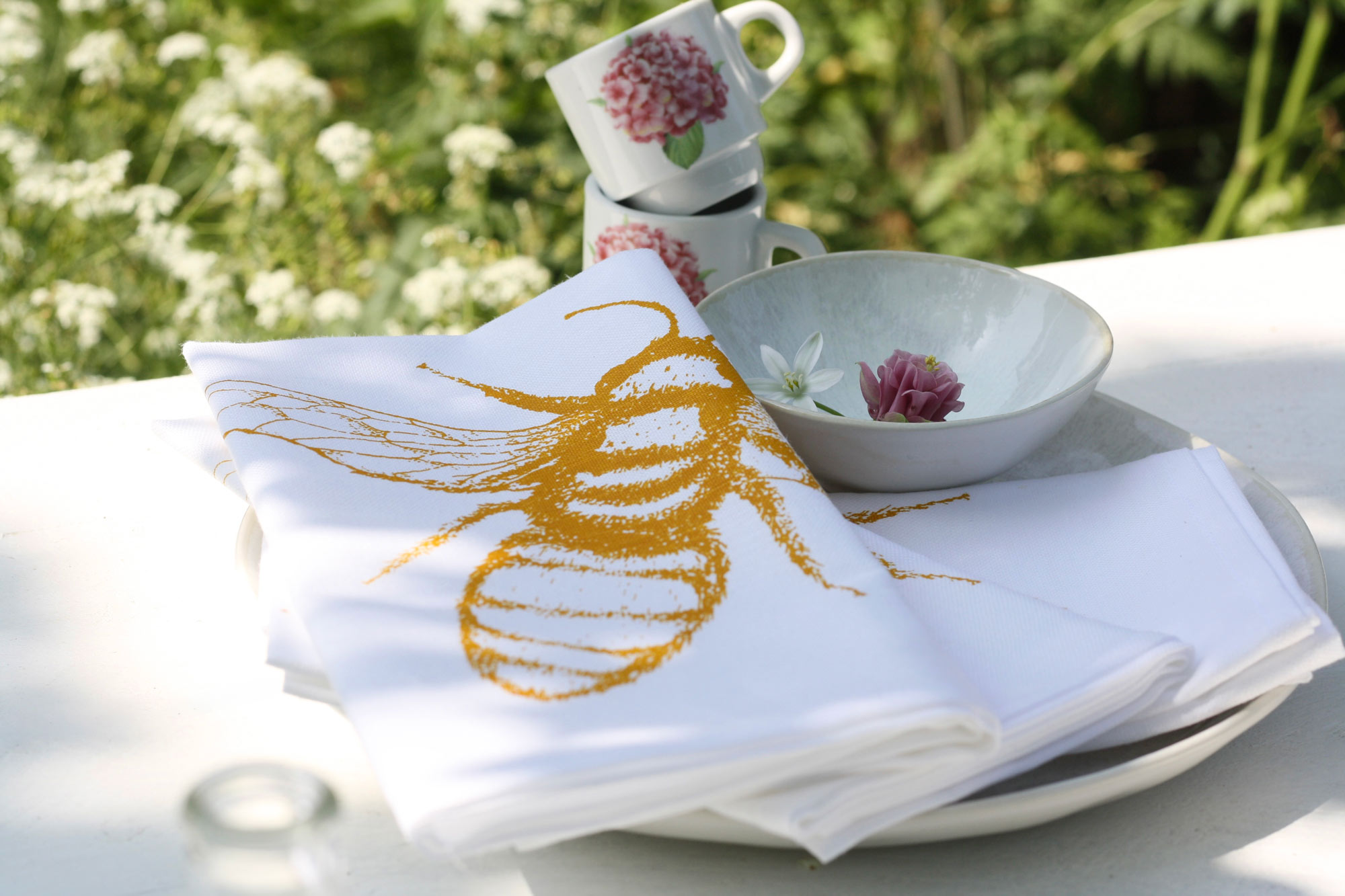 Frohstoff Serviette mit der Biene als Motiv auf gedecktem Tisch