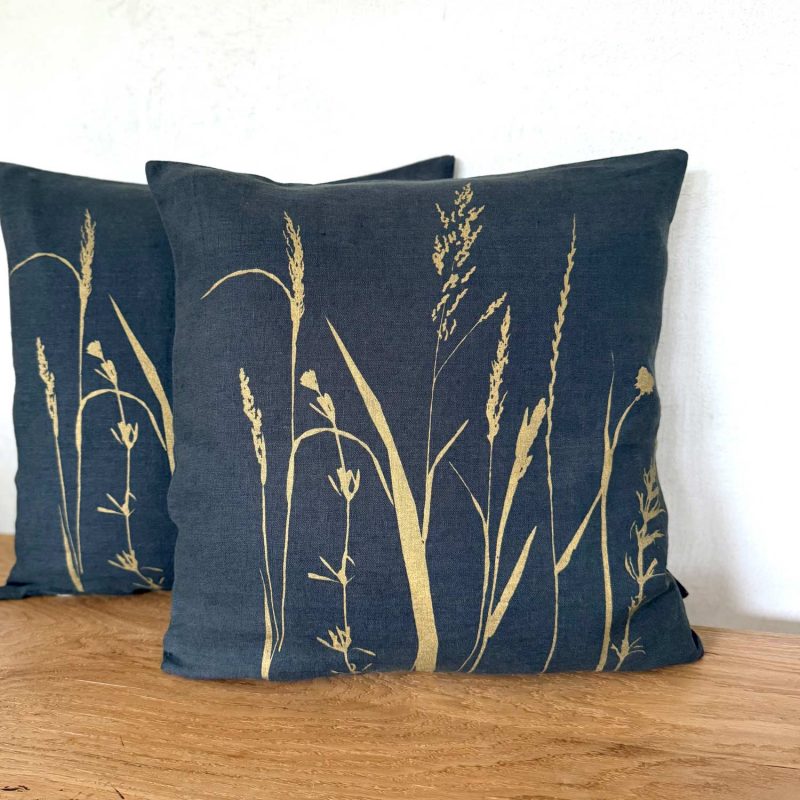 Anthrazitfarbenes Frohstoff Leinenkissen mit dem Motiv Wiese in gold