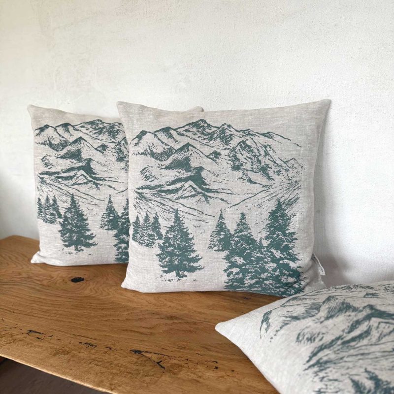 Geflammtes Frohstoff Kissen mit einer Berglandschaft als Motiv in der Farbe rauchgrün