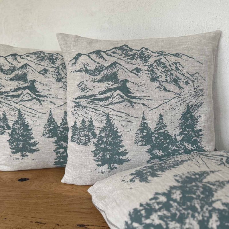 Geflammtes Frohstoff Kissen mit einer Berglandschaft als Motiv in der Farbe rauchgrün