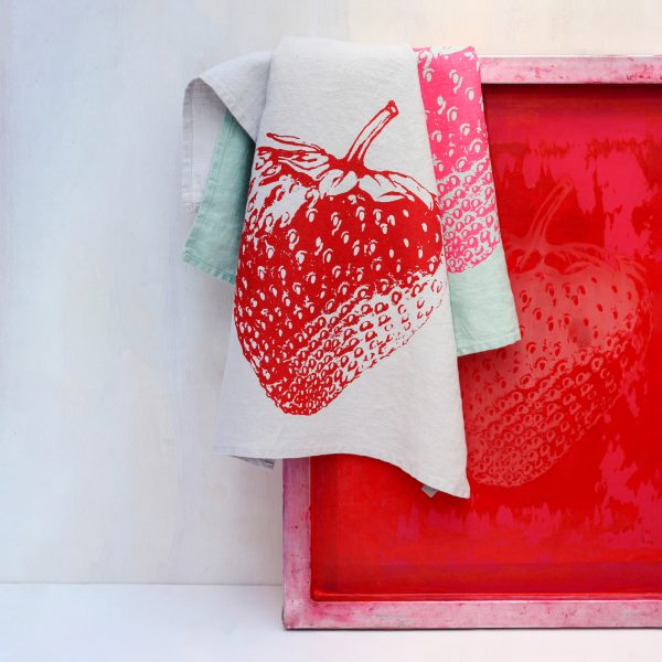 Frohstoff Geschirrtuch aus Leinen Grau mit Erdbeeren-Motiv in Rot auf einen Siebdruckrahmen gelegt