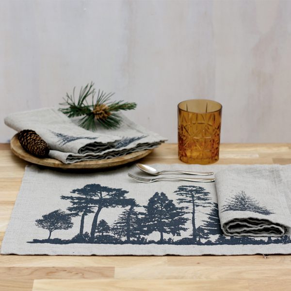 Frohstoff Tischset aus Leinen mit Wald-Motiv und Serviette aus Leinen mit Tannen-Motiv jeweils in Anthrazit auf einem Tisch der dekoriert ist
