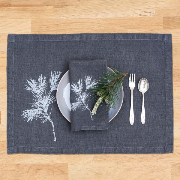 Frohstoff Tischset und Serviette jeweils aus Leinen Anthrazit mit Zweig-Motiv in Eisblau mit einem Teller und Besteck dekoriert